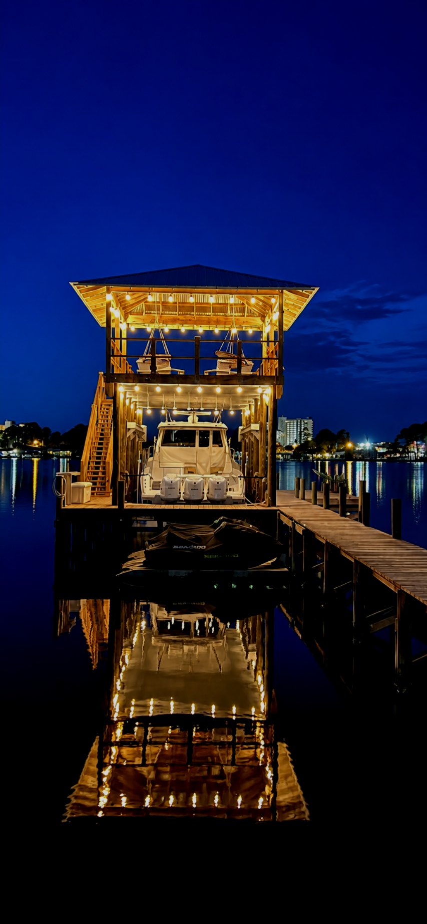 Illuminated boathouse at dusk reflected on the water